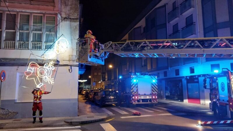 Los bomberos retiran luces navideñas caídas por el viento en Santoña.